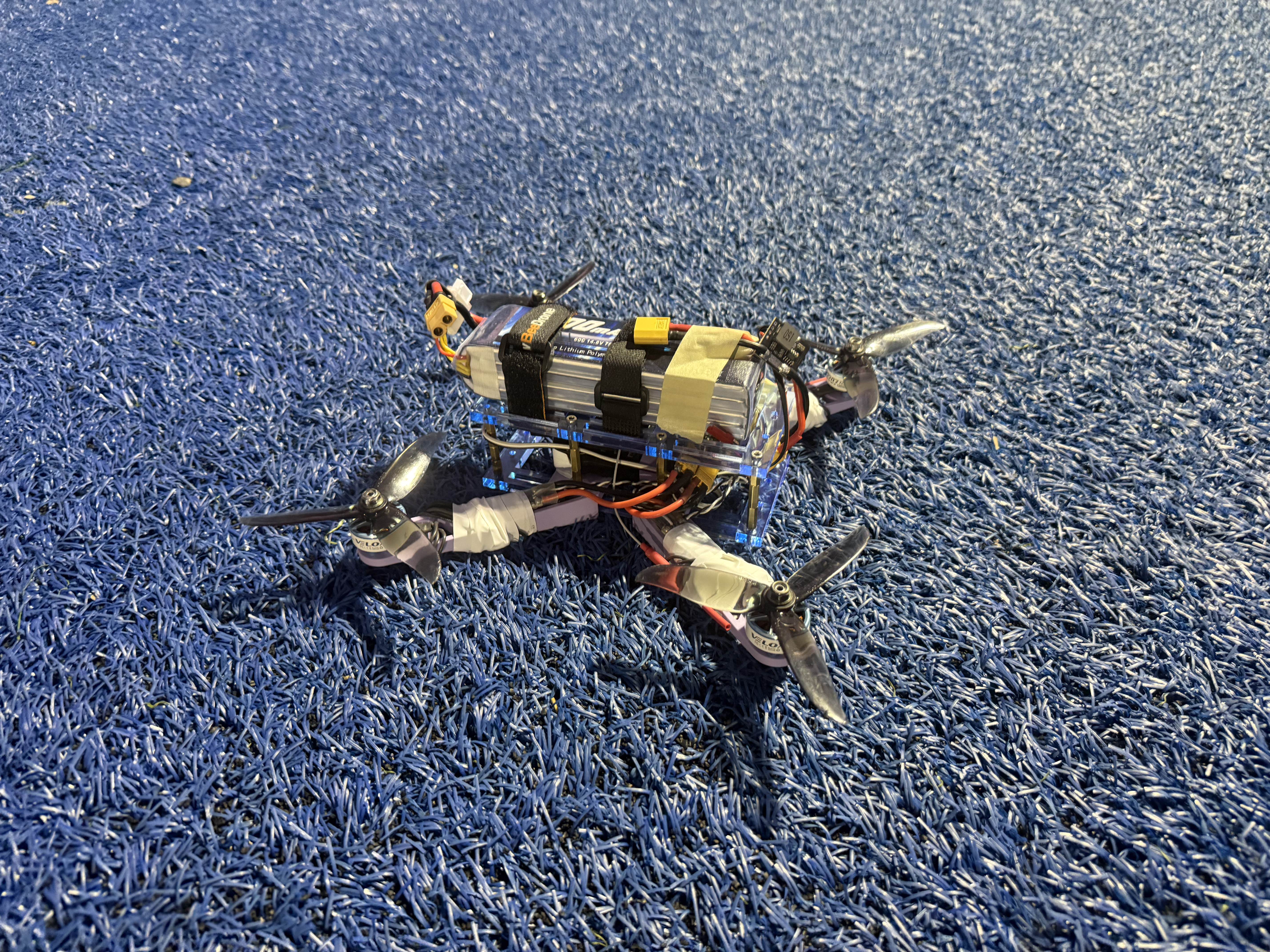 Autonomous quadcopter built for the From Scratch to Sky project, resting on a field before an FPV test flight